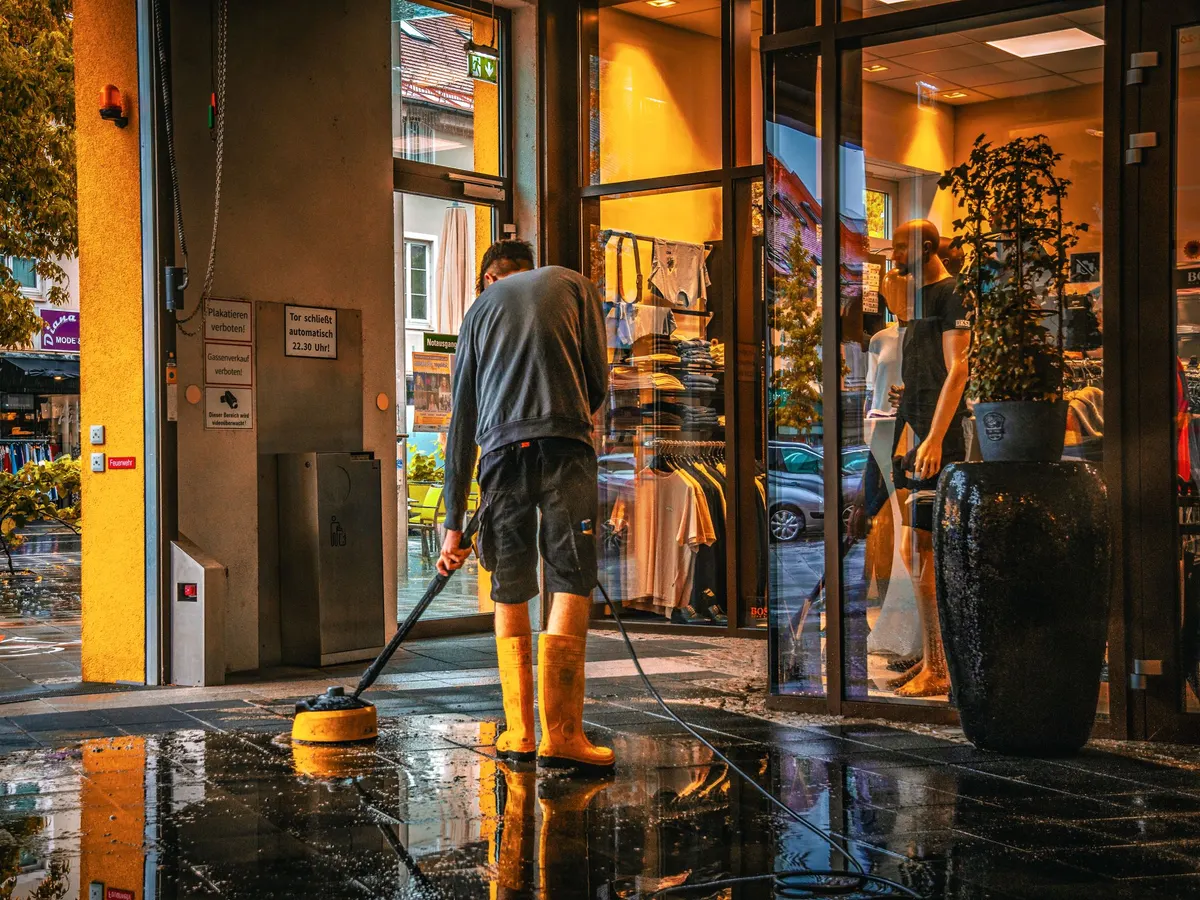 Worker mopping a wet commercial floor